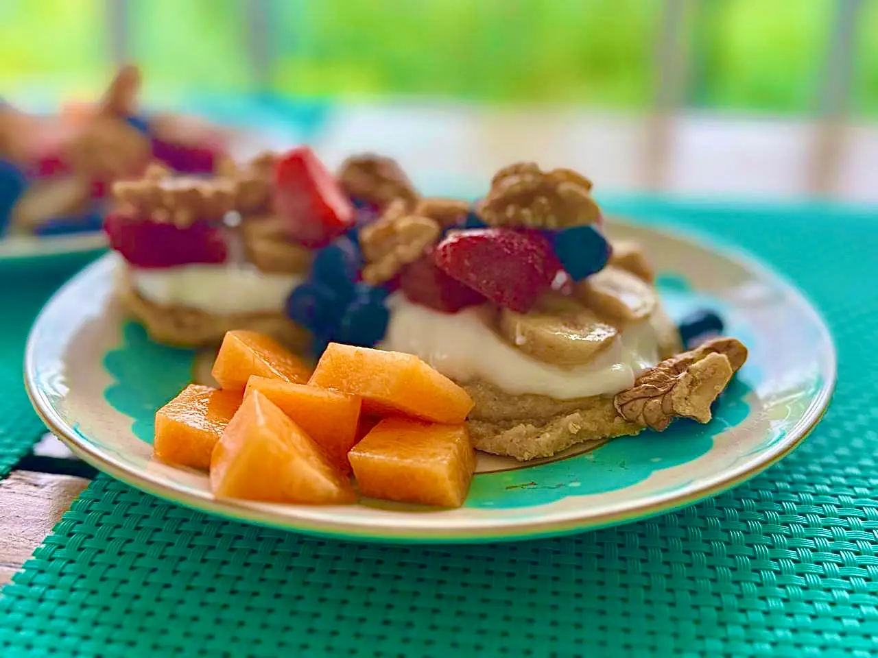 Plato con frutas frescas y yogur sobre mantel verde – Alimentación consciente y saludable