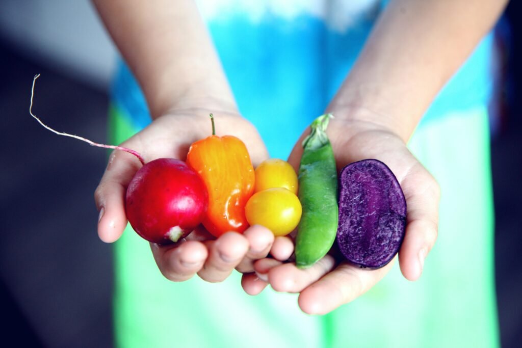Alimentación consciente: manos sosteniendo verduras frescas y coloridas como símbolo de elección nutritiva