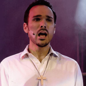 Alejandro Melidoni cantando en el escenario con gran intensidad expresiva, representando el esfuerzo de la técnica y la tensión que genera el sobrepensar los resultados