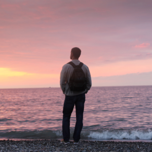 Hombre contemplando el horizonte, metáfora de la paz interior y el camino de autodominio mental